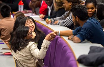 student in a lecture theatre shaking hands with each other