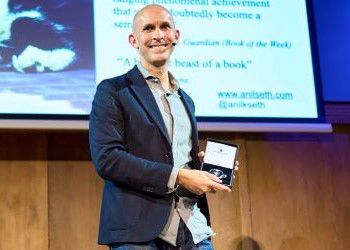 Professor Anil Seth accepts an award on stage