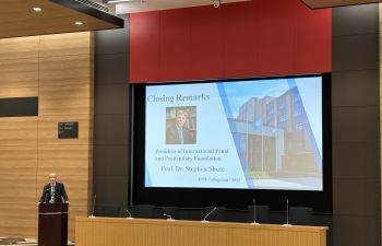 Prof Stehen Shute is shown speaking at a podium with a large screen behind him showing his name and title and 'Closing Remarks'