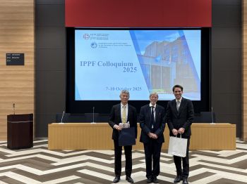 Prof Stephen Shute is shown in front of a large screen showing the name of the colloquium alongside 2 esteemed guests/speakers.