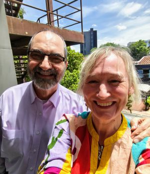 two people, on the left Jorge, a man with short hair beard a glasses, and Serena, woman with short blonde hair, both smiling