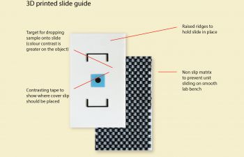 A labelled image of a 3D-printed rectangular platform with contrasting ridges for holding microscope slides in place. There is a square of blue tape central to the ridges with the text 