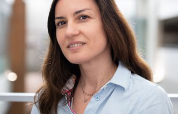 headshot of a smiling woman with long brown hair