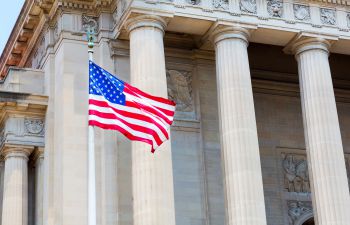 A picture of the US Supreme Court with an American flag waving in front of it