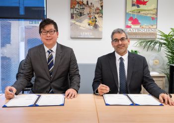 2 individuals with signed papers for the MoU