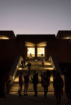 Students walking the library steps at twilight