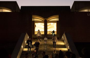 Students walking the library steps at twilight
