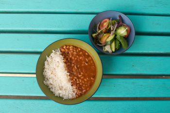 A photo of a plant-based Sussex Saver meal - bean in sauce with rice and a side salad