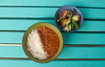 A photo of a plant-based Sussex Saver meal - bean in sauce with rice and a side salad