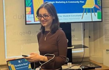 Image of Grace standing in front of a presentation screen