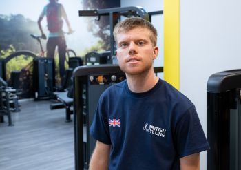 Freddy Ireland seated in the campus gym and smiling at the camera