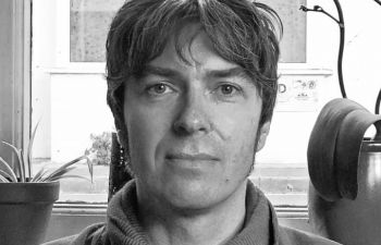 black and white photograph of Jason Douglas face with a window behind him