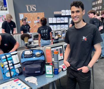 Christopher, who designed the Ostopack, standing next to a table displaying his product