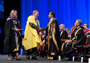 Eric Smith and his daughter Catrine Priestley are greeted by Chancellor Sanjeev Bhaskar and Vice-Chancellor Sasha Roseneil