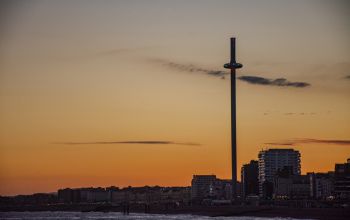 A sunset image of the the Brighton cityscape and seafront i360, shot from the Brighton pier.