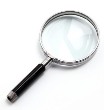 A silver magnifying glass with a black handle, on a white background.