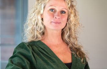 A professional portrait photo of Rebecca Stephens smiling at the camera