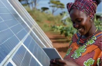 A lady stood next to solar panels
