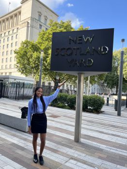 Samara (Media and Communications BA) standing outside with the New Scotland Yard sign