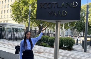 Samara (Media and Communications BA) standing outside with the New Scotland Yard sign