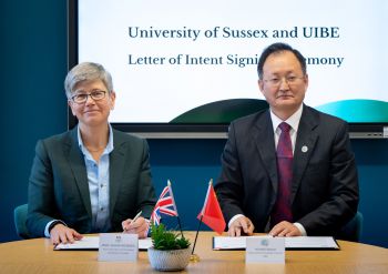 woman and man seated signing a document