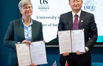 The Sussex Vice-Chancellor and President of UIBE hold up formal agreements that they have signed on behalf of Sussex and UIBE