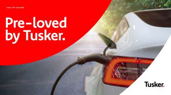 'pre loved cars' written in white on red semi-circle background in top right hand corner. Grey car in the remaining part of the image with 'Tusker' written in black on the bottom right corner.