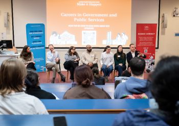 A panel a alumni speakers facing a lecture theatre