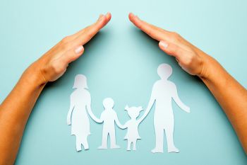 Paper family in hand isolated on blue background