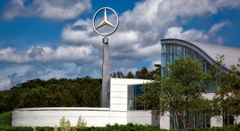 A Mercedes Benz car showroom from the outside with large logo