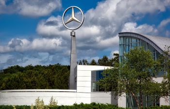 A Mercedes Benz car showroom from the outside with large logo