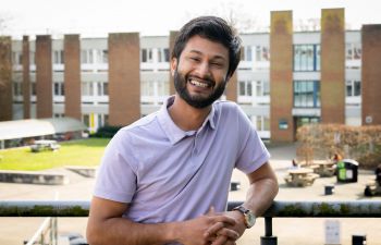 Robin Choudhary stood outside smiling with a courtyard and buildings in the background.