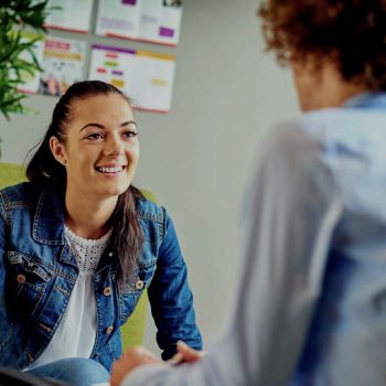 Image of two people facing each other chatting