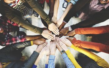 A group of people putting their hands into the middle