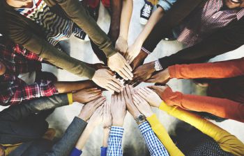 A group of people putting their hands into the middle