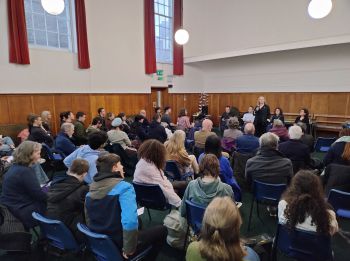 a photo showing the audience and the panel, being introduced by Sarah Sawyer