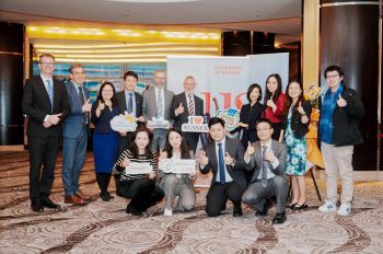 Group of academics and students in China smiling at camera with thumbs up