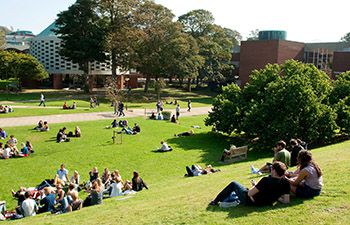Sussex students laying on the grass in the sunshine