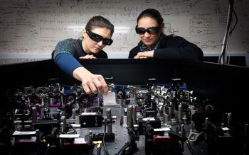 Two researchers stand over a quantum computer array