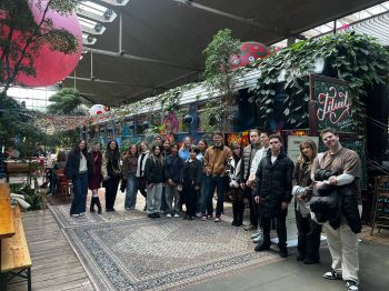 Students standing smailing at an indoor venue Station F