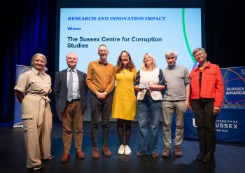 A photograph of the team behind The Sussex Centre for Corruption Studies on stage at the awards ceremony with the VC, Prof Sasha Roseneil, stood at the far right of the group.