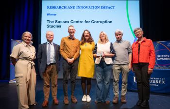 A photograph of the team behind The Sussex Centre for Corruption Studies on stage at the awards ceremony with the VC, Prof Sasha Roseneil, stood at the far right of the group.