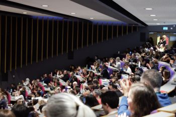 A packed auditorium of attendees in a Sussex lecture theatre