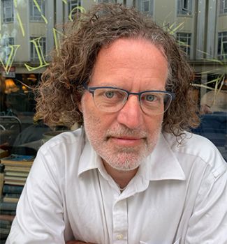 white man with brown wavy collar length hair