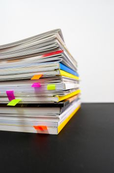 Pile of books with coloured bookmarks marking pages
