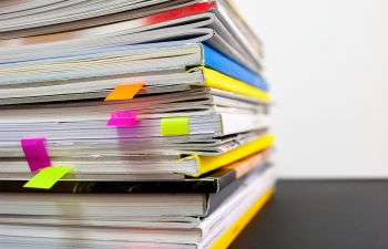 Pile of books with coloured bookmarks marking pages