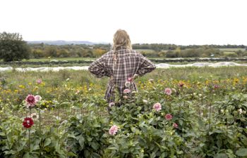 One of the women farmers stands on her farmland