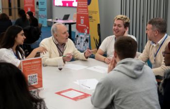 Students and alumni having discussions around a table in the Student Centre.