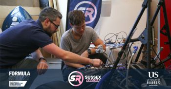 Students working on some technical equipment in a workshop