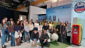 students standing by Vespa scooters at the museum